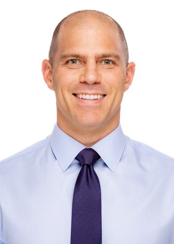 A man in a blue shirt and purple tie.