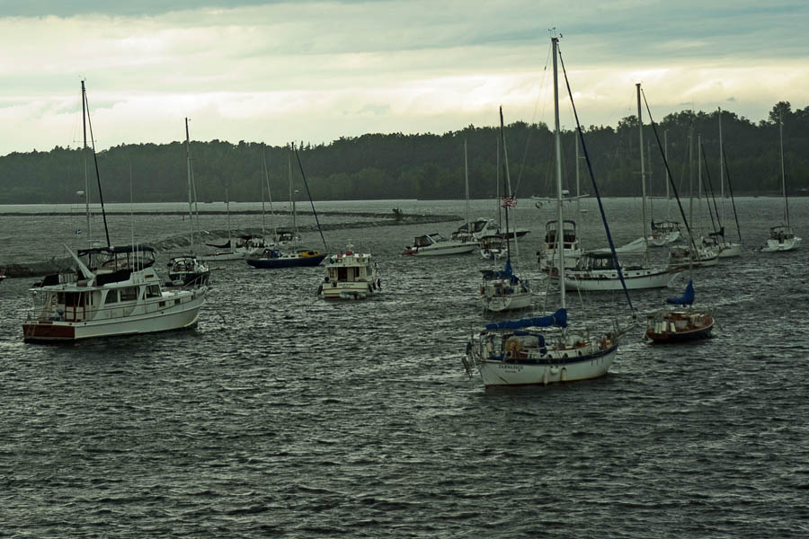 A group of boats in the water at dusk.