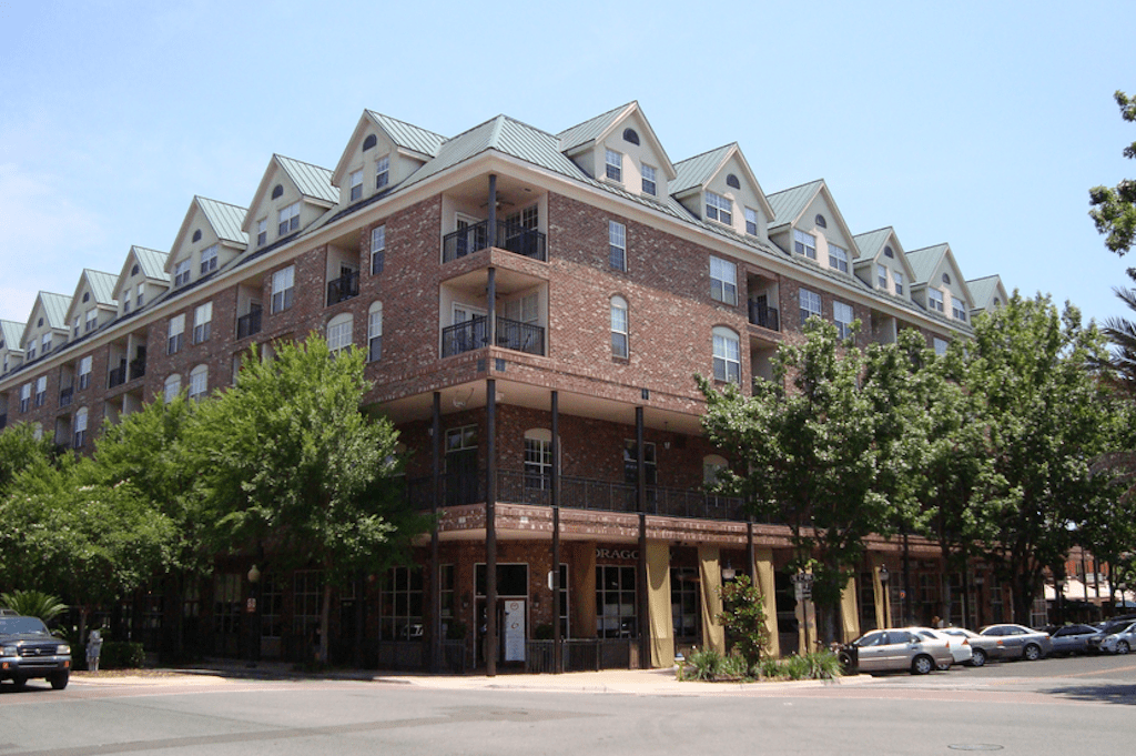 A large brick building with cars parked on the side.