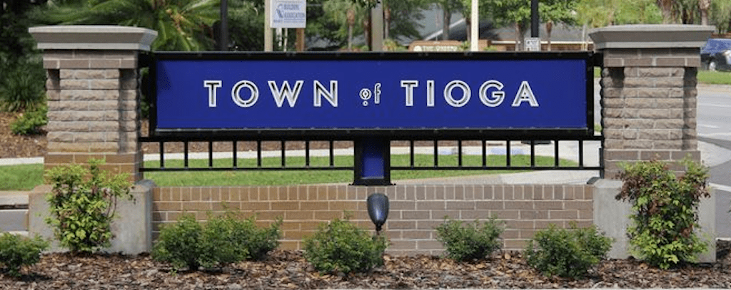 A blue sign that says town of tioga.