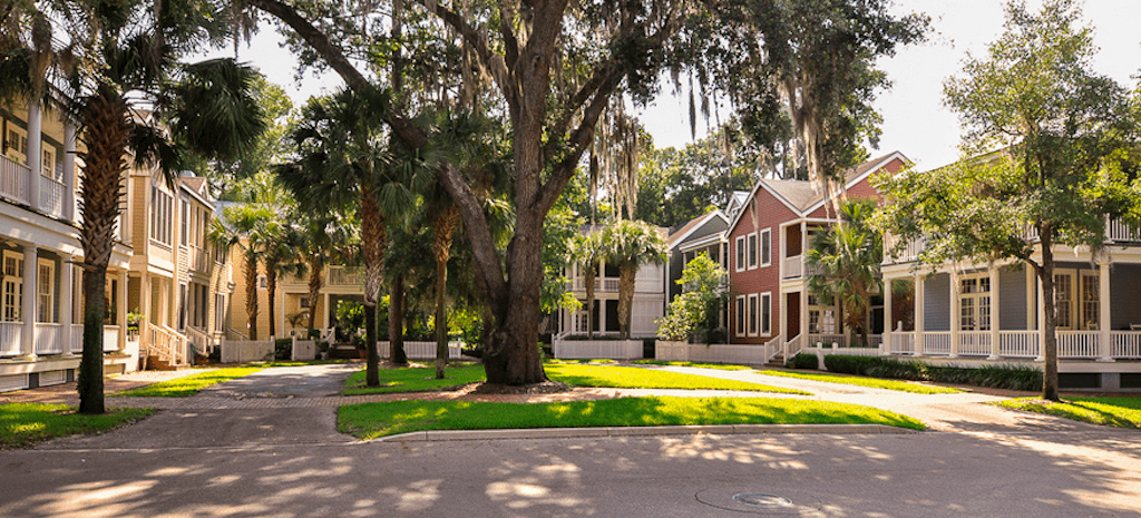 A street with many trees and houses in the background