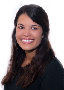 A woman with long hair smiles for the camera.