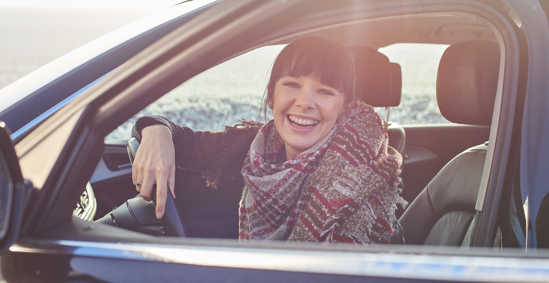 Woman smiling in driver seat representing auto insurance coverage with McGriff-Williams Insurance